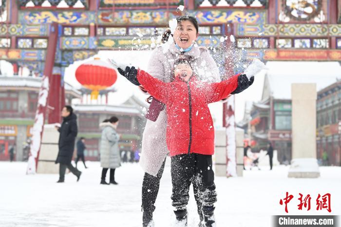 2月13日，家長與小朋友在呼和浩特市大召廣場享雪趣?！⑽娜A 攝
