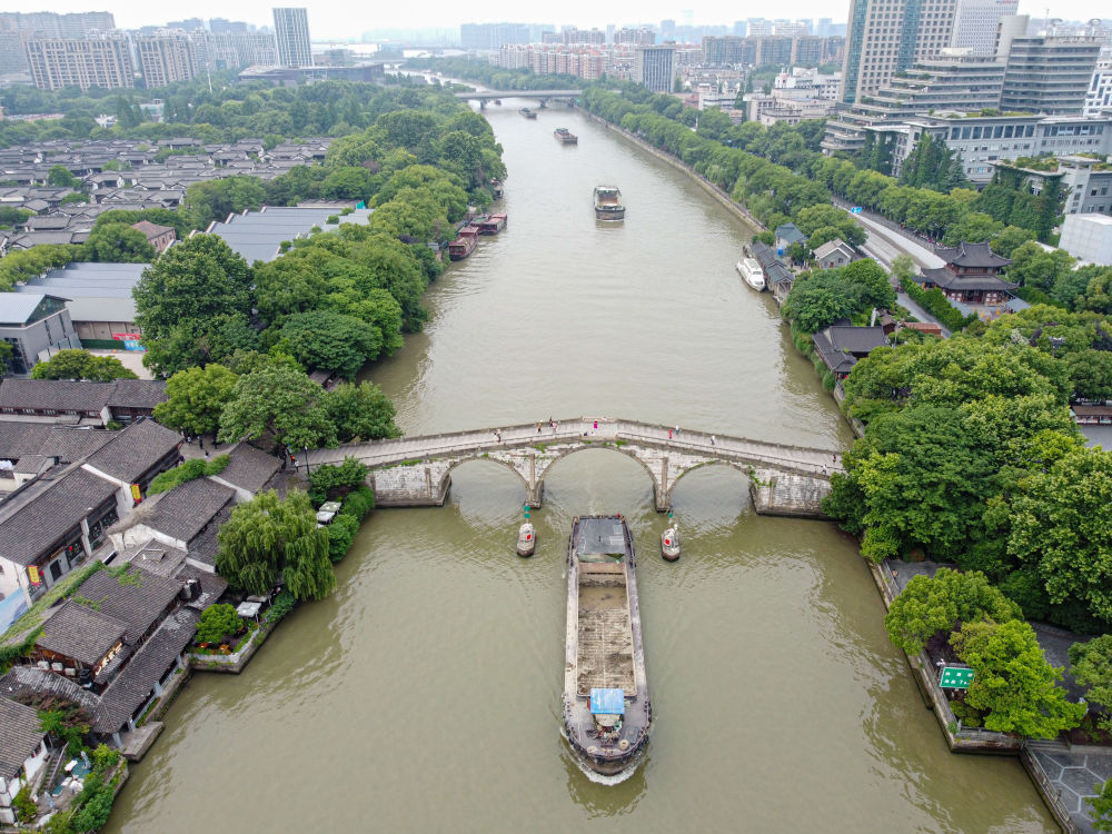 5月27日，一艘貨船駛過(guò)京杭大運(yùn)河南端標(biāo)志建筑杭州拱宸橋。(無(wú)人機(jī)照片)新華社記者江漢 攝