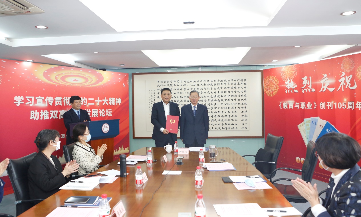 郝明金為《教育與職業(yè)》雜志編委代表陳曉明頒發(fā)聘書。中華職教社供圖