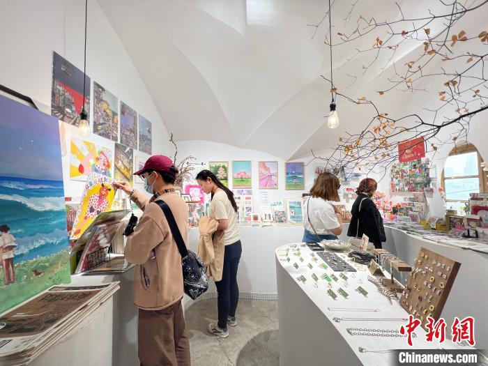 圖為藝術(shù)品商店內(nèi)，顧客挑選插畫(huà)作品。　鐘旖 攝