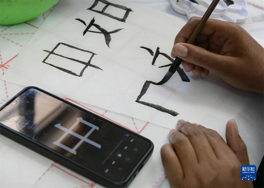 4月18日，肯尼亞學(xué)生在內(nèi)羅畢大學(xué)孔子學(xué)院舉辦的活動(dòng)上寫毛筆字。肯尼亞內(nèi)羅畢大學(xué)孔子學(xué)院18日舉辦“中文，增進(jìn)文明對(duì)話”主題活動(dòng)，慶祝即將到來(lái)的第14個(gè)聯(lián)合國(guó)中文日。肯尼亞學(xué)生參與互動(dòng)，進(jìn)行書法、剪紙、唱中文歌等活動(dòng)。新華社記者 韓旭 攝