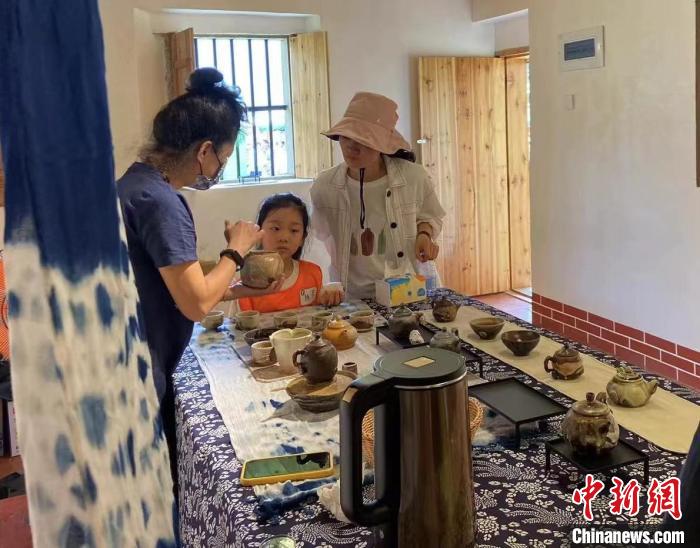 圖為：游客正在咨詢臺(tái)灣柴燒作品?！∪~秋云 攝