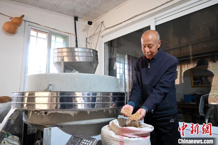 李家莊村民谷文朝重拾父輩的手藝，做起石磨面粉的營生?！〉杂鸺?攝