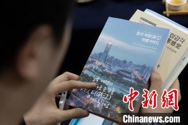 參展觀眾閱讀浙江文旅手冊?！《≌裾?攝