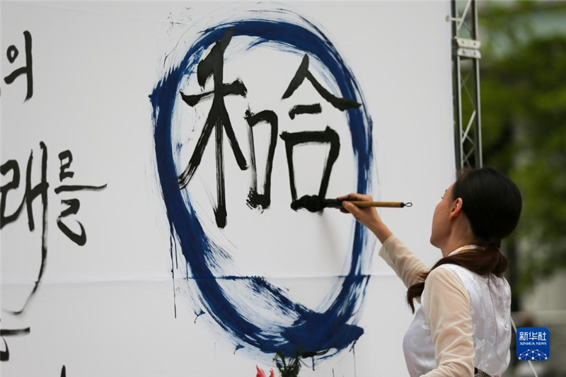 5月30日，在韓國首爾舉辦的“中日韓合作之日”慶?；顒又校硌菡哌M行中日韓精神——2023年度漢字“和合”書法表演。新華社記者 王益亮 攝