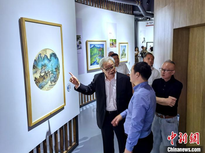 海峽兩岸藝術(shù)家畫展上，藝術(shù)家進行藝術(shù)交流?！「毒窜?攝