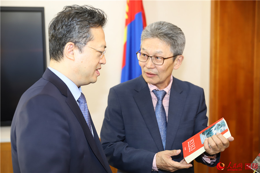其米德策耶（右一）向李峙介紹翻譯成果。人民網(wǎng)記者 霍文攝