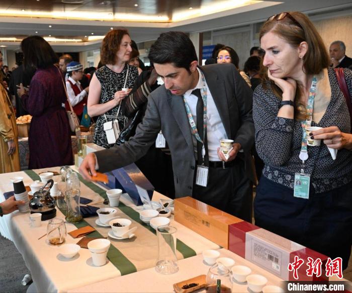 現(xiàn)場觀眾觀看中國展臺茶藝表演、了解茶文化。　靖樹 攝