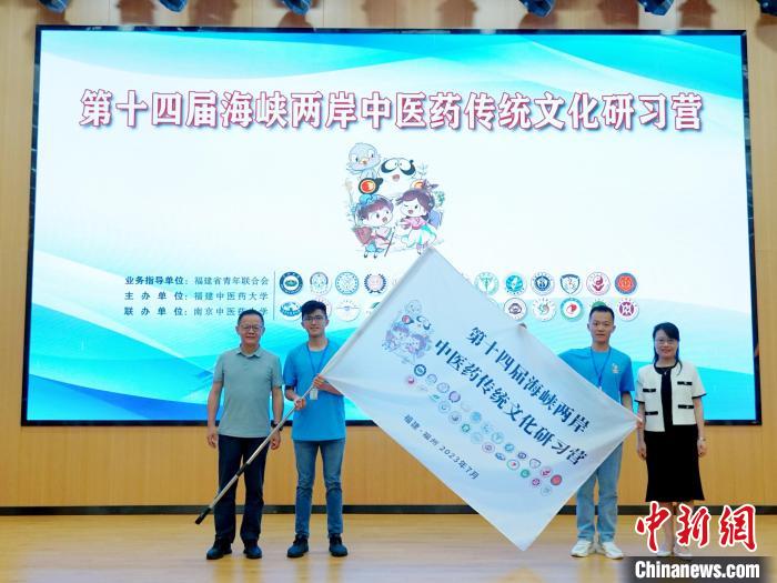 共青團(tuán)福建省委副書(shū)記吳雪(右一)、福建中醫(yī)藥大學(xué)黨委副書(shū)記林羽(左一)為兩岸學(xué)生代表頒授營(yíng)旗?！≡S燁婷 攝