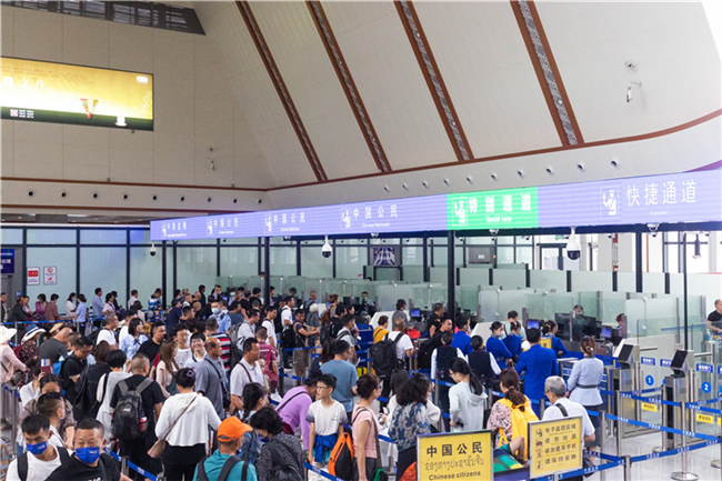 7月22日，乘坐中老鐵路國(guó)際旅客列車(chē)的旅客在磨憨邊檢大廳排隊(duì)候檢。衛(wèi)海林 攝