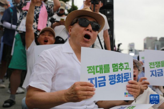 7月22日，在韓國首爾，人們手舉標(biāo)語參與反戰(zhàn)游行。新華社發(fā)（楊暢 攝）
