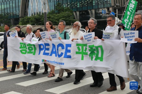 7月22日，在韓國首爾，人們手舉標(biāo)語參與反戰(zhàn)游行。新華社發(fā)（楊暢 攝）