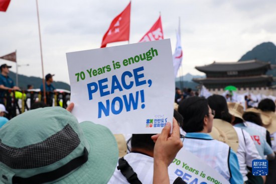 7月22日，在韓國首爾，人們手舉標(biāo)語參與反戰(zhàn)游行。新華社發(fā)（楊暢 攝）