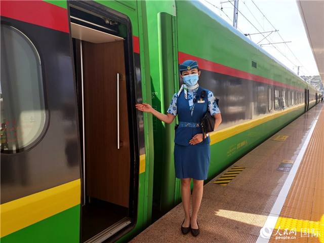 趙瑩靜站在“復(fù)興號”國際旅客列車車廂門口歡迎旅客上車。人民網(wǎng) 杜明明攝