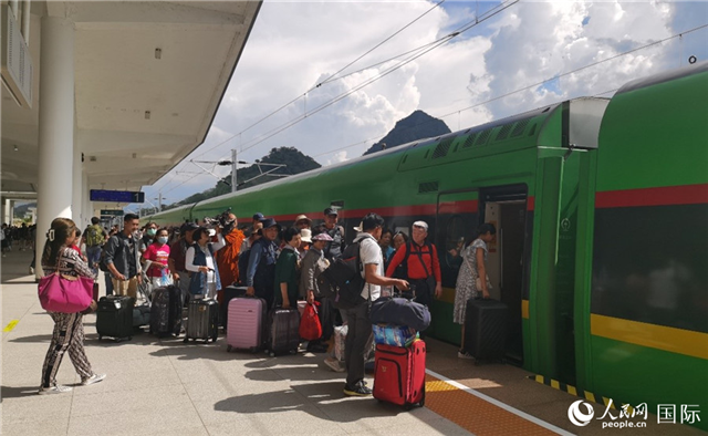 乘坐中老鐵路國際旅客列車的旅客在老撾瑯勃拉邦站排隊(duì)上車。人民網(wǎng)記者 杜明明攝