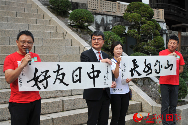 東京中國(guó)文化中心主任羅玉泉展示其為本次活動(dòng)書寫的題詞“中日友好，山高水長(zhǎng)”。人民網(wǎng) 蔣曉辰攝