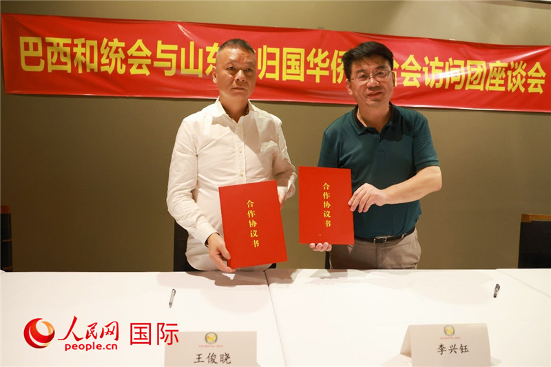 中國(guó)僑聯(lián)副主席、山東省僑聯(lián)主席李興鈺（右）與巴西和統(tǒng)會(huì)會(huì)長(zhǎng)王俊曉簽署合作協(xié)議書(shū)。人民網(wǎng)記者 陳海琪攝