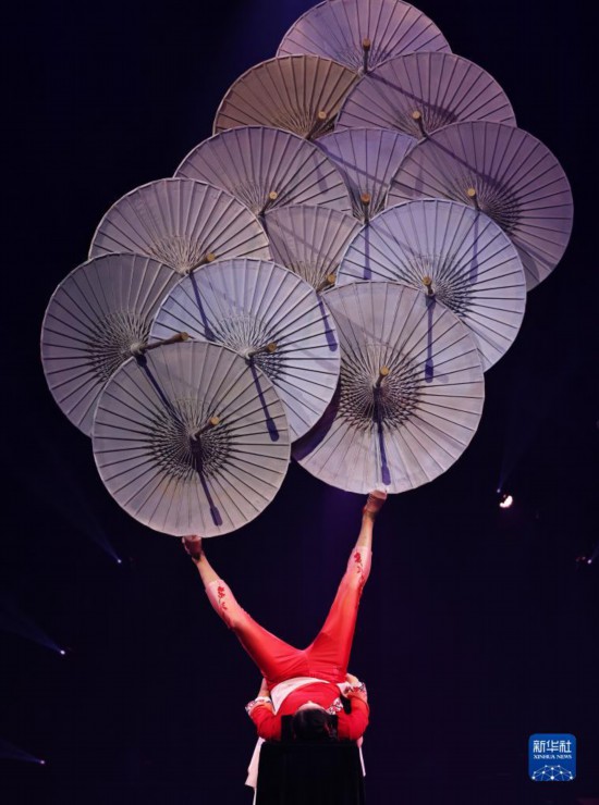 12月8日，演員在法國(guó)巴黎舉行的中國(guó)雜技“奇妙之夜”演出上表演《蹬傘》。新華社記者 高靜 攝