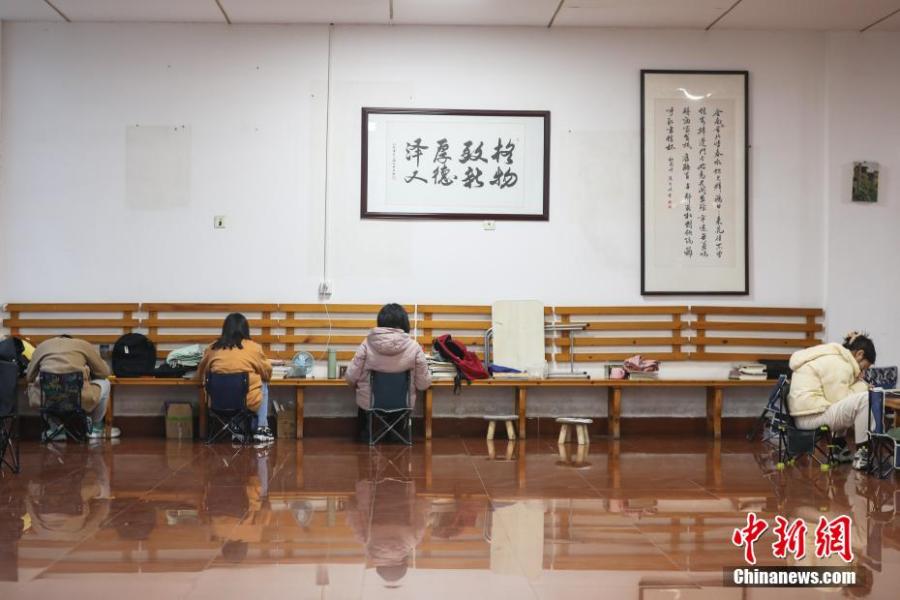 資料圖：幾位考研學(xué)生在南昌大學(xué)教學(xué)樓的公共空間復(fù)習(xí)備考。劉力鑫 攝