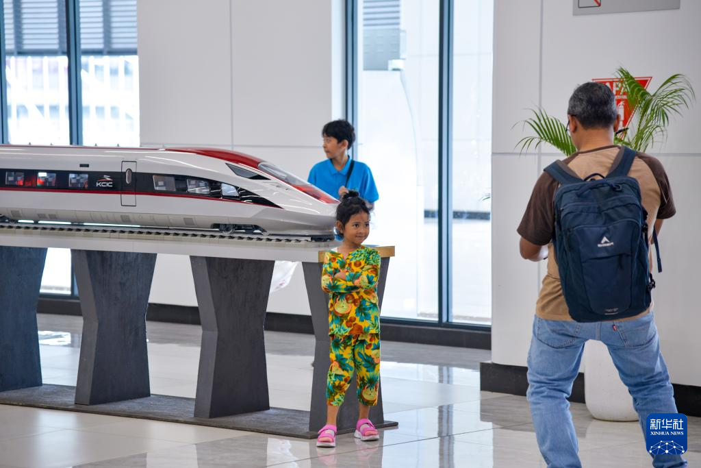 1月24日，在印度尼西亞雅加達(dá)哈利姆站候車大廳，一名小朋友和雅萬高鐵高速動車組模型合影。新華社記者 徐欽 攝