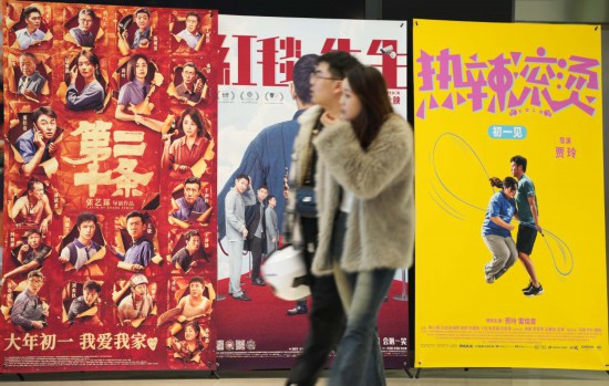 這是2月17日，在沈陽一家影院，觀眾從海報(bào)前經(jīng)過。新華社記者李鋼攝