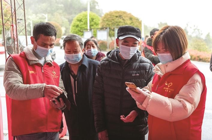 長沙縣黨員志愿者正在幫助參與核酸檢測的群眾掃描“場所碼”。劉思源 攝