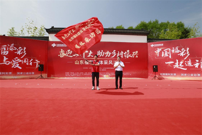 為媒體采風(fēng)團(tuán)授旗。 山東省福彩供圖