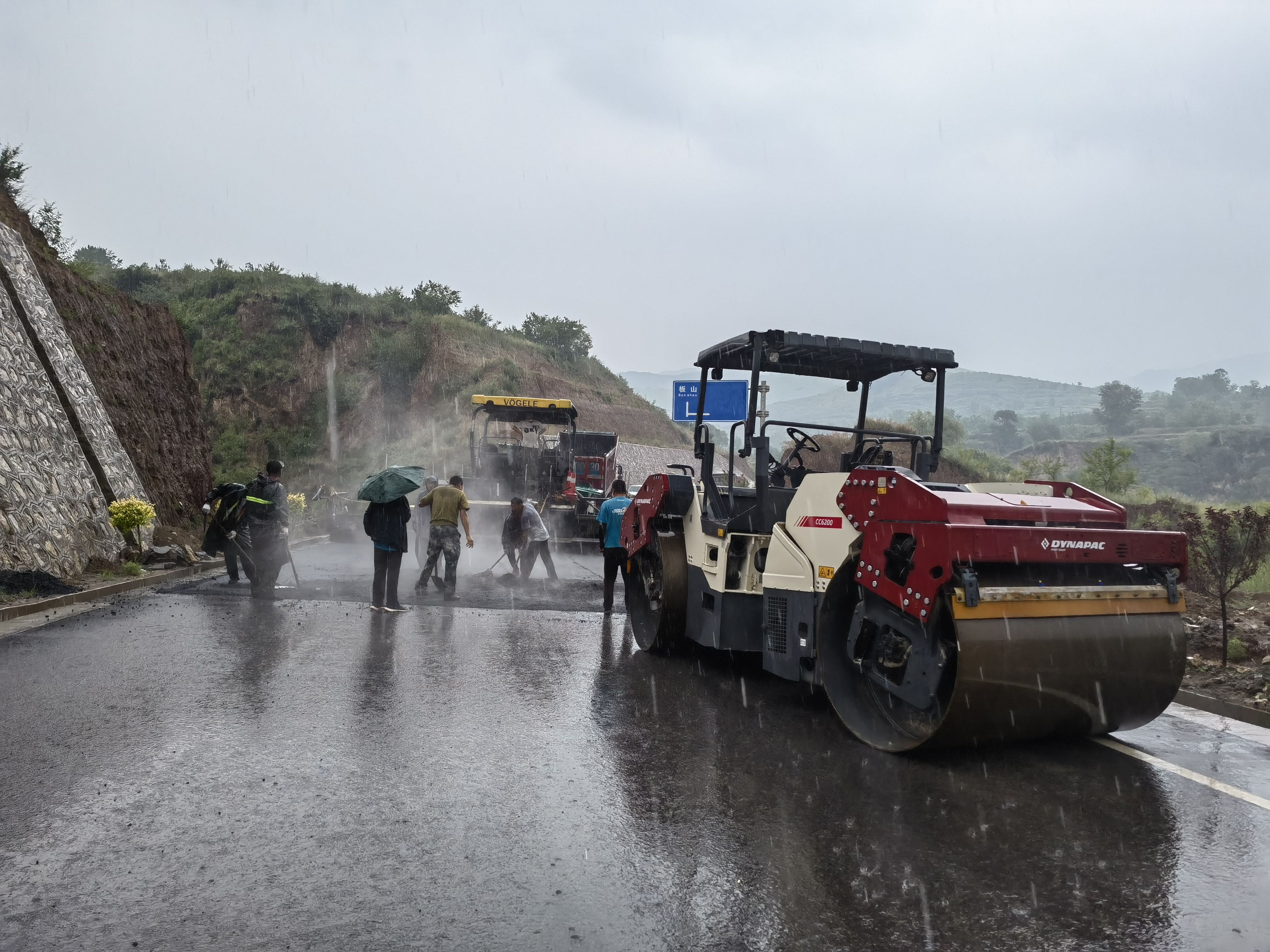 路橋工人在大雨中搶修道路。李華英 攝