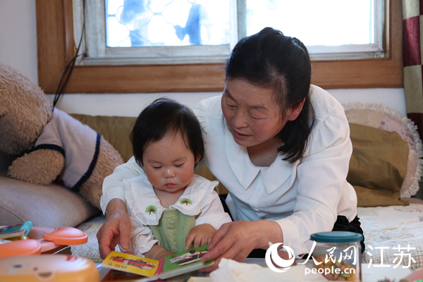 王繼蓮帶孫女看童書(shū)。人民網(wǎng) 冷金明攝