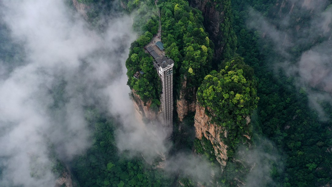 位于張家界武陵源景區(qū)的百龍?zhí)焯蓁偳对谠旗F繚繞的峰林間，雄偉壯觀。吳勇兵攝