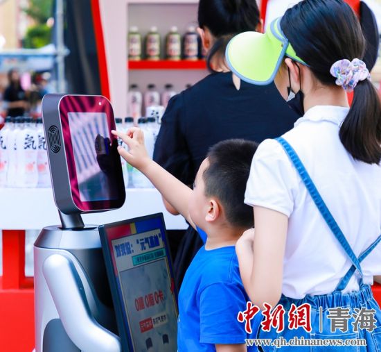 圖為一名小朋友正在和機(jī)器人“志愿者”進(jìn)行互動(dòng)。 沐聞 攝