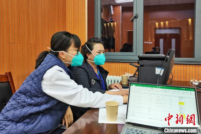 8月9日，楊蘇喬(左)在拉薩方艙醫(yī)院指揮部讀取艙內(nèi)患者胸部CT。　受訪者供圖