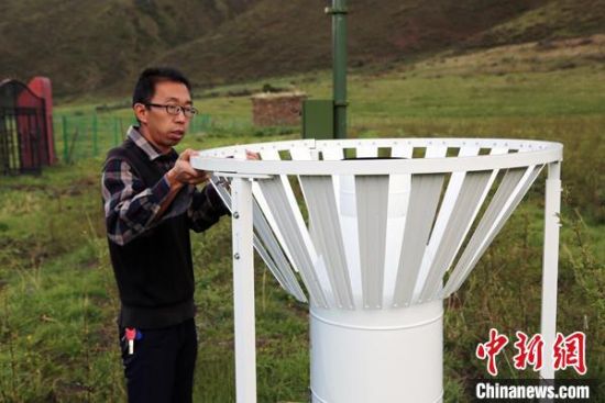 圖為班瑪縣氣象局工作人員在維護(hù)藏雪茶基地氣候站。青海省氣象局供圖