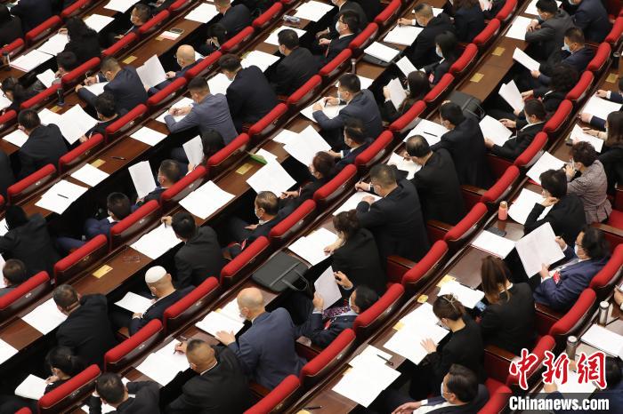 圖為會議現(xiàn)場，參會代表正在聽取政府工作報告?！∑钤鲚?攝