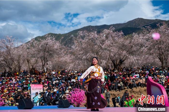 桃花林下精彩的“桃花仙子”選拔吸引村民或游客。　劉忠俊 攝