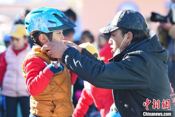 圖為拉薩市實驗幼兒園孩子在教練的幫助下穿戴頭盔?！『闻罾?攝