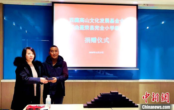 圖為西藏高山文化發(fā)展基金會理事長溫麗向聶榮縣完全小學(xué)負(fù)責(zé)人捐助儀器?！∮谫e 攝