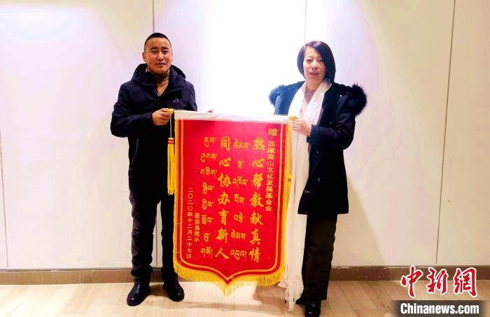 圖為聶榮縣完全小學(xué)向西藏高山文化發(fā)展基金會贈送錦旗?！∮谫e 攝