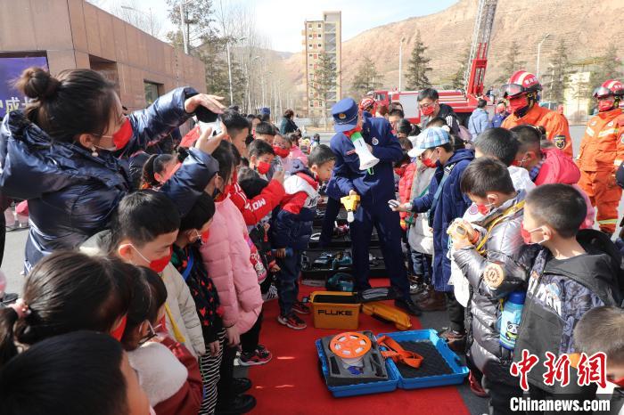 圖為小朋友們聽(tīng)消防員講解消防器材?！铨埥?攝