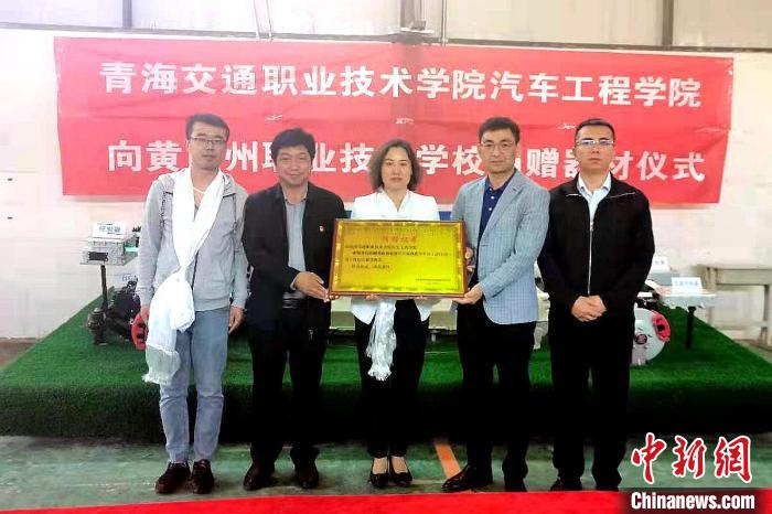 圖為李富香(中)代表學(xué)校為州縣技校捐贈器材。(資料圖) 青海省教育廳供圖