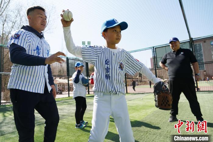 圖為教練指導(dǎo)小棒球手?jǐn)S球技術(shù)?！●R銘言 攝