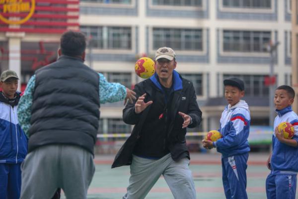 在高原上教孩子們打手球，“慢慢兒來，甭著急！”