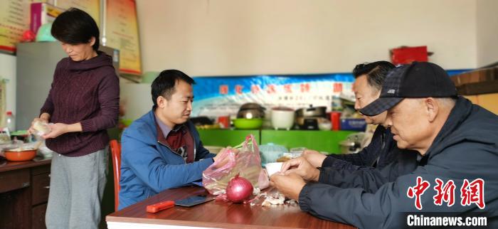 圖為扶貧路上“臨時(shí)一家人”準(zhǔn)備午餐?！∥航ㄜ?攝