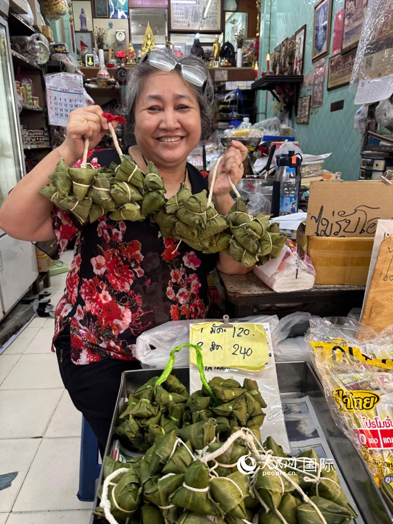 商家向顧客介紹“吉掌”（粽子的一種，一串一串，個(gè)頭較小）。人民網(wǎng)記者 簡承淵攝