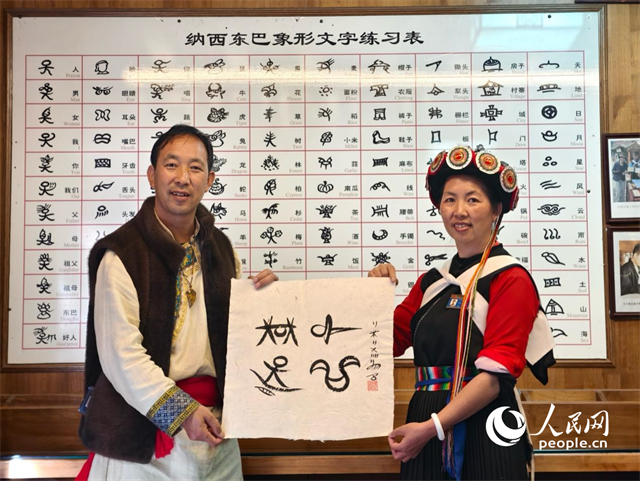 人民網(wǎng)“行進中國”云南調(diào)研采訪團走進麗江，和閏元現(xiàn)場用東巴文寫下“行進中國”。人民網(wǎng)記者 符皓攝