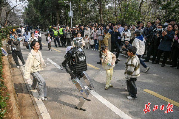 “智警小珞”人形機(jī)器人和小朋友們斗舞。長江日報(bào)記者史偉 攝