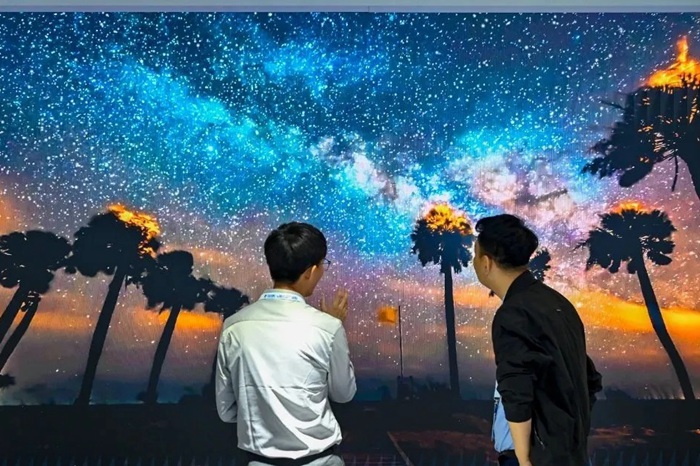 長春光博會希達電子展區(qū)，一位工作人員正在給一位觀眾講解。（長春新區(qū)供圖）