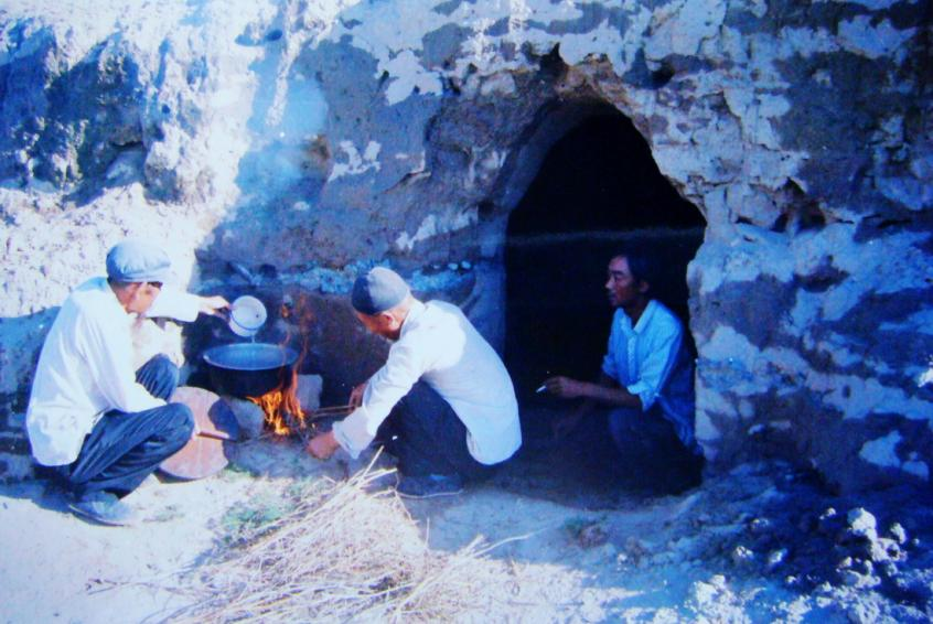 1983年，“六老漢”一代治沙人在“地窩子”生活做飯。新華社發(fā)（八步沙林場(chǎng)供圖）