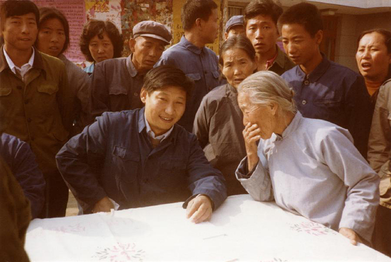 1983年，時(shí)任河北正定縣委書記的習(xí)近平（前排居中），臨時(shí)在大街上擺桌子聽取老百姓意見。