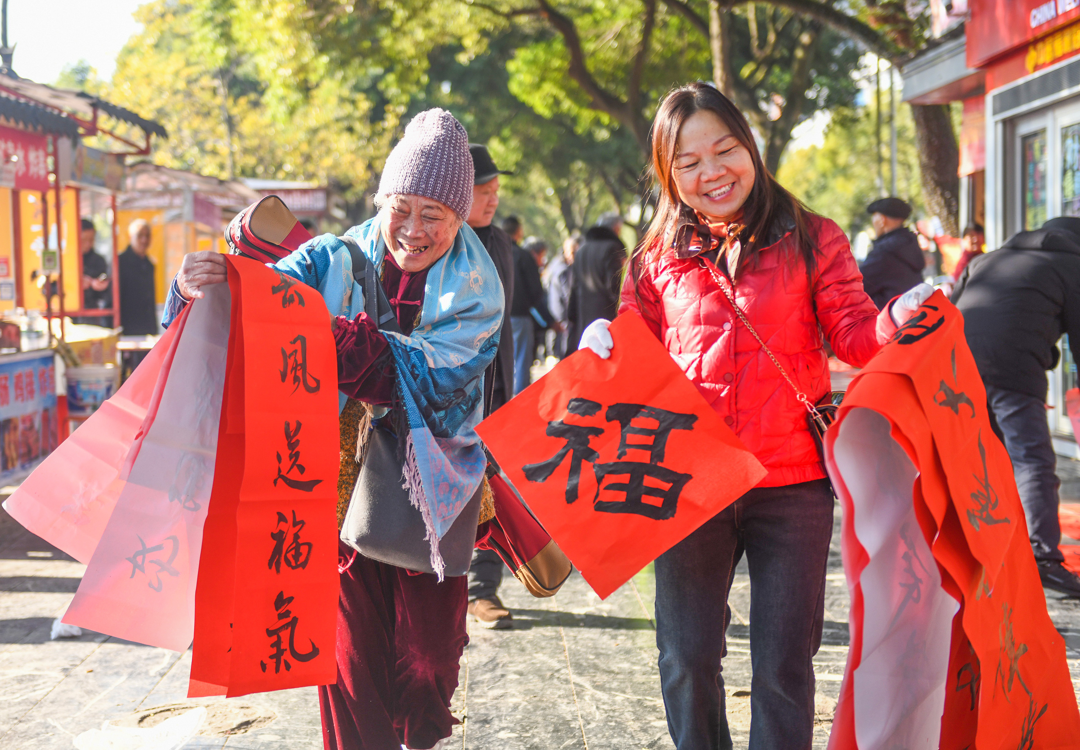 2025年1月13日，在湖南省永州市道縣西洲公園義工崗亭，市民們領到了書法志愿者為大家書寫的春聯。